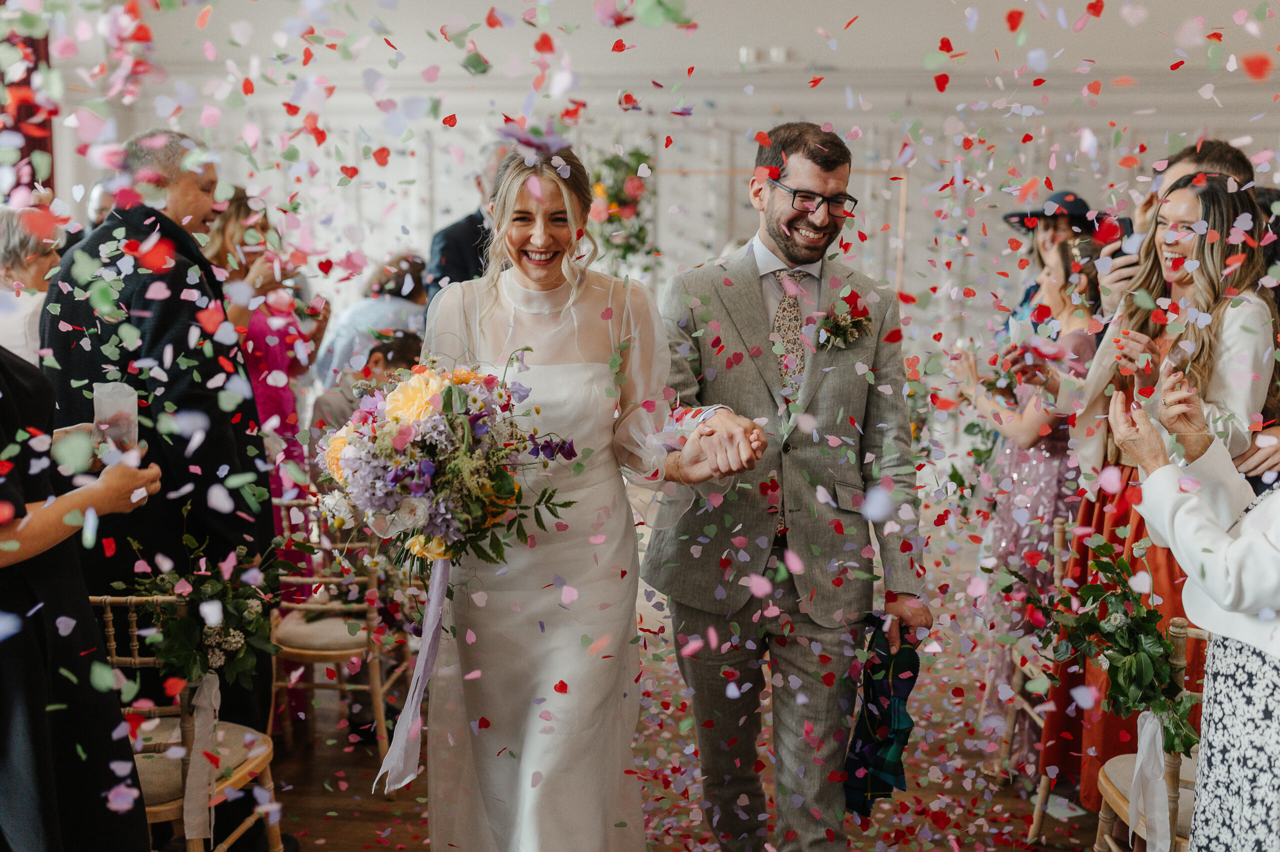 Couple at wedding with colourful confetti.